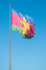 The flag with the coat of arms of the Krasnodar Territory flutters in the wind.