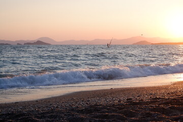 wind surfer surfing on sunset