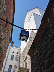 A narrow passage with a lantern suspended on chains, between the stone walls of the Vyborg Castle...