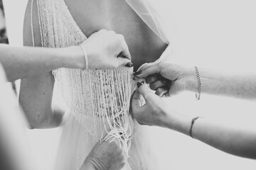 Hands of bridesmaids on bridal dress. Happy marriage and bride at wedding day concept