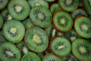 Top view of heap of sliced kiwi as textured background.