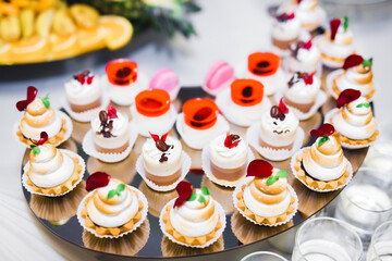 Delicious sweets on wedding candy buffet with desserts, cupcakes