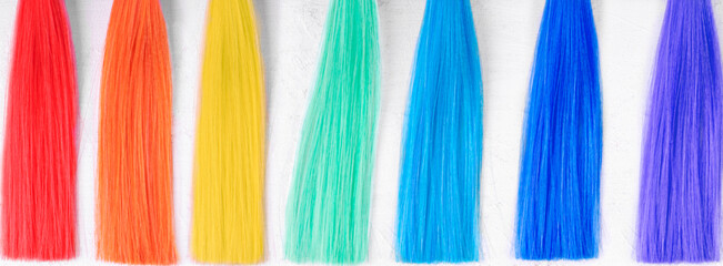 Hair dye samples in seven rainbow colors on white. Flat lay. Web banner
