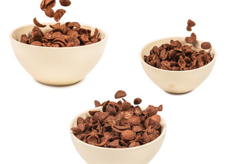 Chocolate corn flakes falling to the white bowl isolated on white. Motion.