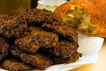 Cutlets, fritters, from beef liver lie a slide on a plate next to the bread ciabatta