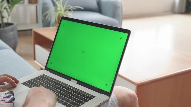 Close Up Man Using Laptop Computer With Green Screen At Living Room
