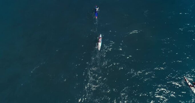 Aerial view of paddle surfing racers in mediterranean blue water of sea. Summer water sport activities in Spanish coast. 