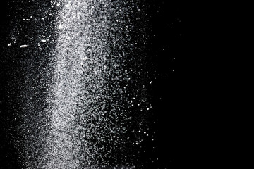 White powder explosion. White powder splash isolated on black background. Flour sifting on a dark...