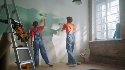Young couple making house renovation indoors. Family painting in new apartment.