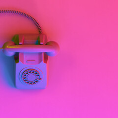 Vintage Phone in Neon Studio Lighting on a Magenta Pastel Background. 3D Rendering with Copy Space.
