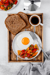 breakfast with fried eggs ang vegetables, toasts and coffie.  hight key