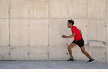 Athletic man running and doing exercise outdoors.