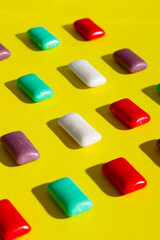 Multi-colored chewing gum on a yellow background