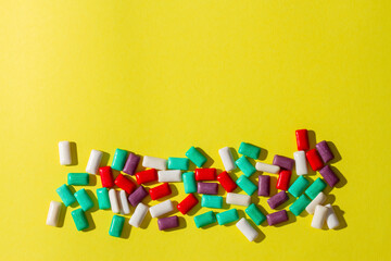Multi-colored chewing gum on a yellow background