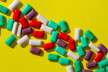 Multi-colored chewing gum on a yellow background