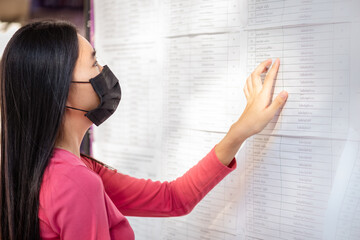 Student is looking for a name from the exam results on the board. At university ,Back to school...