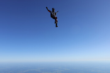 Fototapeta na wymiar Skydiving. Solo girl is flying in the sky