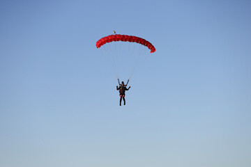 Skydiving. The girl is piloting a parachute and landing.