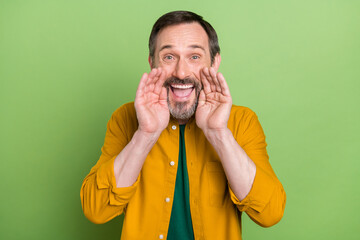 Photo of mature handsome man hands near mouth speak yell announcement advertise isolated over green color background