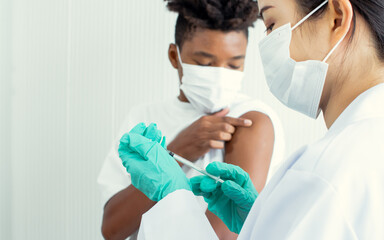 Selective focus doctor hand wearing medical green glove, holding syringe with hypodermic needle for...