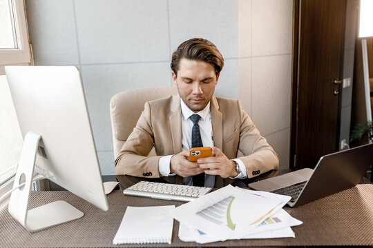 Handsome Pensive Caucasian Businessman Hold Mobile Phone Distracted From Work Conference Online, Self-employed Man Solve Business Issues, Have A Break After Online Meeting Distantly Concept