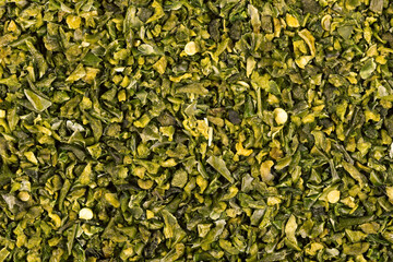 Dried green paprika flakes with seeds background. Chopped jalapeno, habanero or chilli pepper. Spices and herbs.
