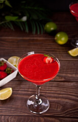 Cold strawberry margarita or daiquiri cocktail with lime and rum