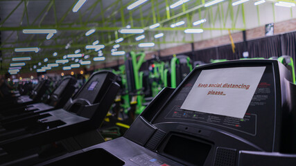 New normal Gym and Fitness. The treadmill is labeled message "Keep Social distancing" and Some treadmills are activated to prevent the spread of coronavirus.