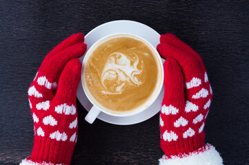 Woman hand with red gloves holding coffee cup.