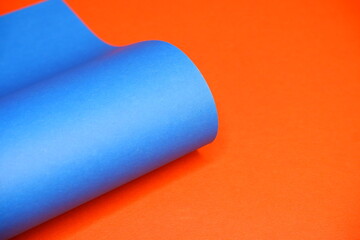 Blue cardboard on an orange background. The texture of the cardboard.