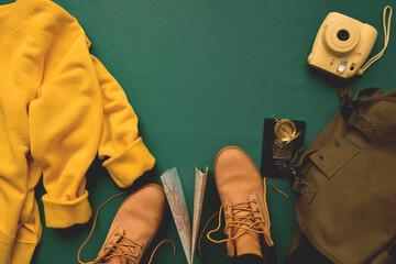 Travel essential items on dark green background with copy space in the middle