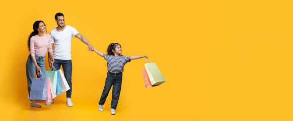 Seasonal Sales. Happy Middle-Eastern Family With Little Daughter Carrying Bright Shopping Bags