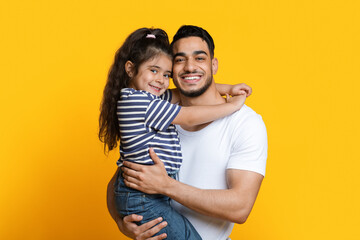 Portrait Of Happy Young Arab Dad Holding His Little Daughter On Hands
