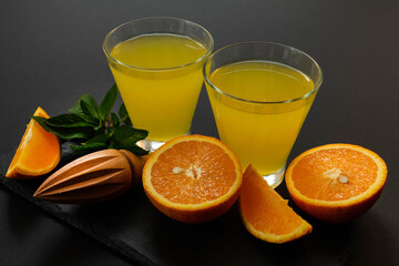 Orange lemonade with mint on a black background.