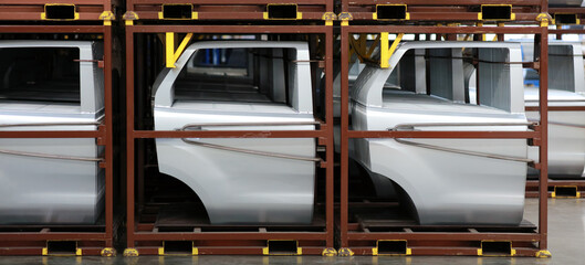 Vehicle Door panel parts on steel rack in warehouse supply to automotive production factory, production concept