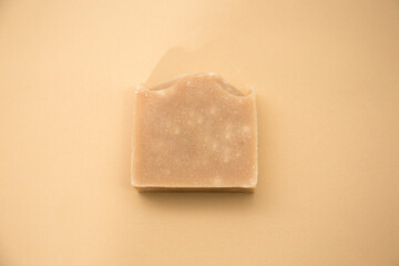 Top view of hand made soap bar isolated on brown background 