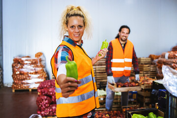 Two people a young man and a girl,work in a fruit and vegetable warehouse and hawe a good time.