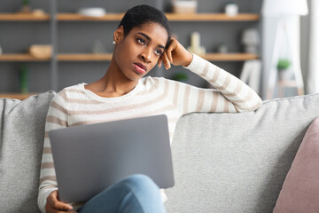 Lack Of Inspiration. Bored Black Freelancer Lady Sitting With Laptop On Couch