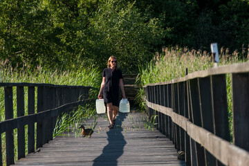 Ekero, Sweden A woman carries jugs of potable water on a dock.