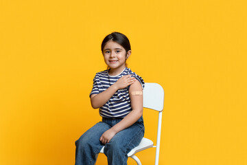 Portrait Of Cute Little Arab Girl Showing Arm After Coronavirus Vaccination