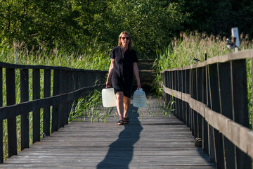 Ekero, Sweden A woman carries jugs of potable water on a dock.