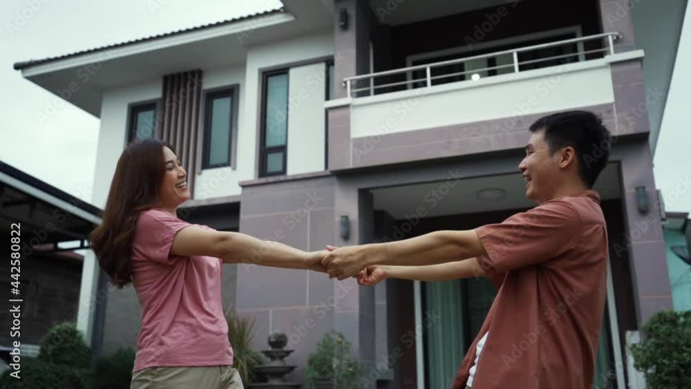 Wall mural slow-motion of cheerful young couple outside their house