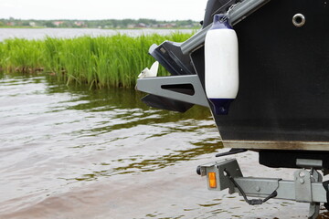 Motor boat launching into the water, side view of the transom stern and the inflatable fender...