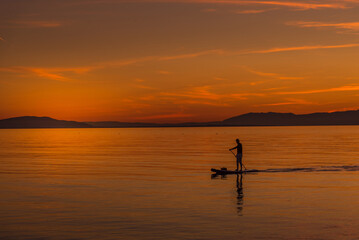 Unrecognized person during beautiful sunset in the coast from a body board table