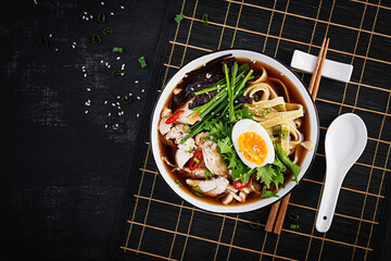 Miso soup. Japanese ramen soup with chicken, egg, nori and  nipposinica on dark background. Top...