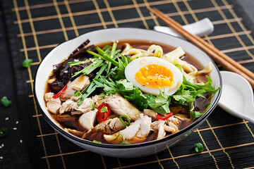 Miso soup. Japanese ramen soup with chicken, egg, nori and  nipposinica on dark background.