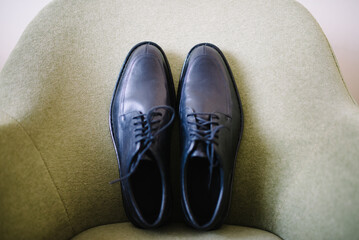 black lace up leather shoes on an armchair