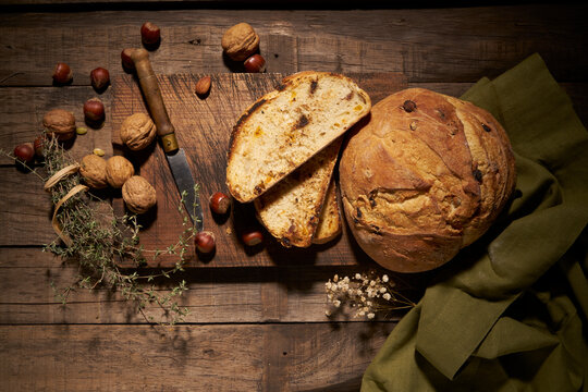 Rustic bread with nuts on wooden board