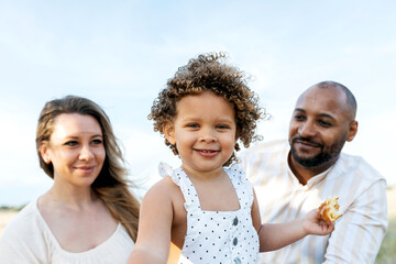 Smiling multiracial family having picnic in summer