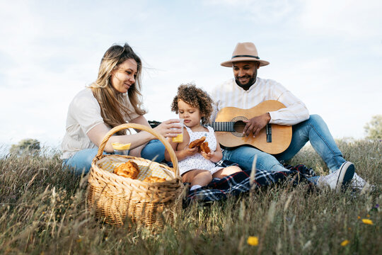 Happy multiethnic family having picnic in nature